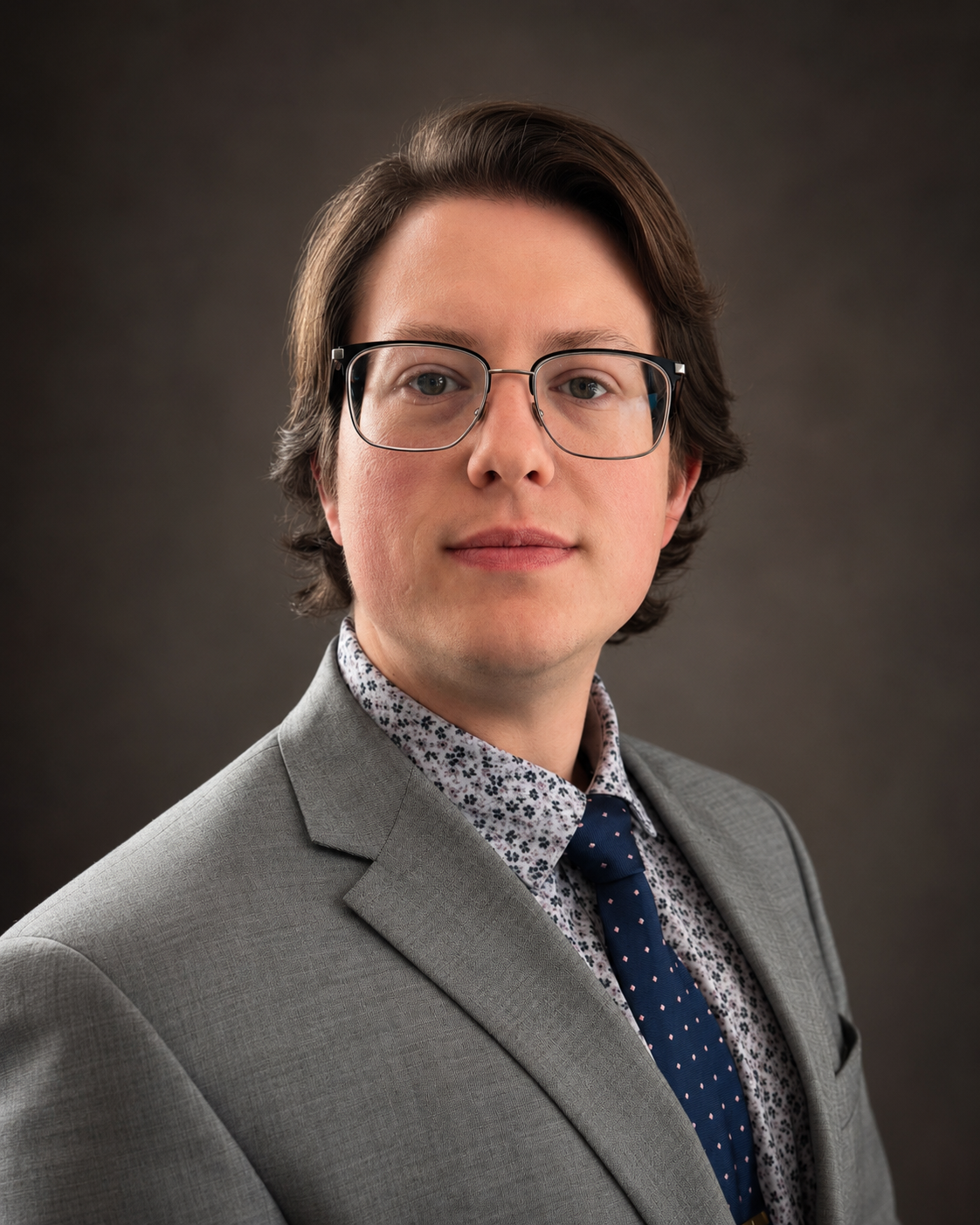 Portrait of Jeremiah Richmond in a light gray suit, patterned shirt, and blue tie.
